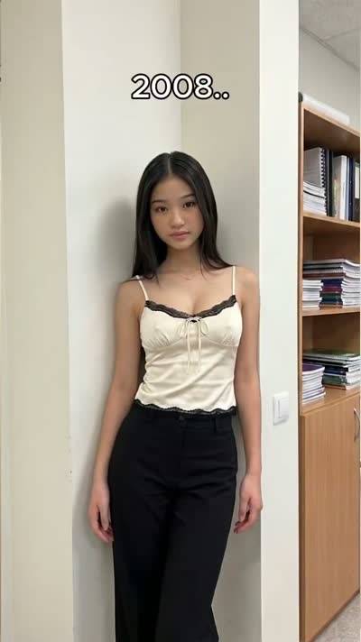 Dark-haired in a cream lace cami and black trousers