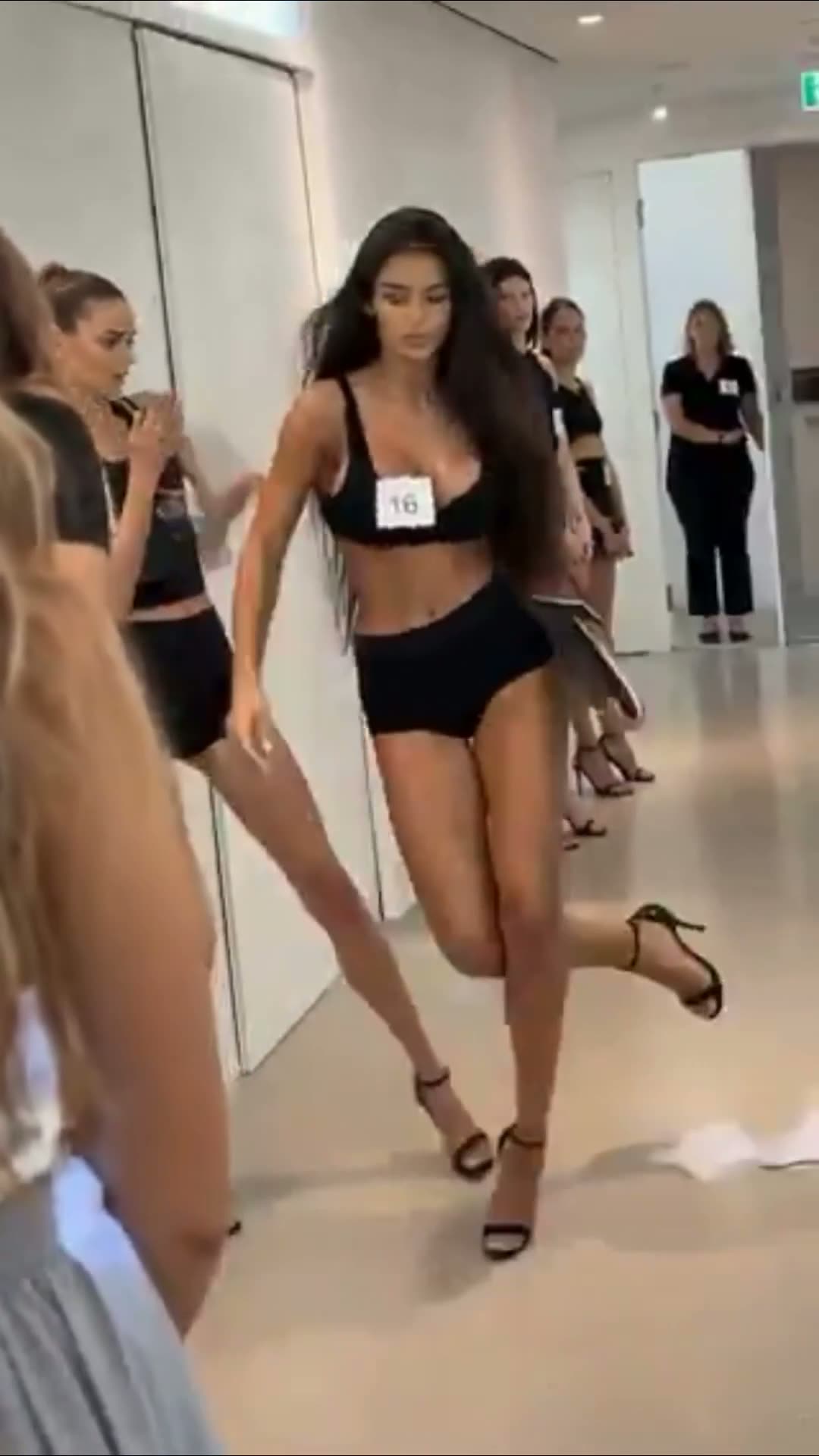 Women in black bikinis and heels at a casting line-up