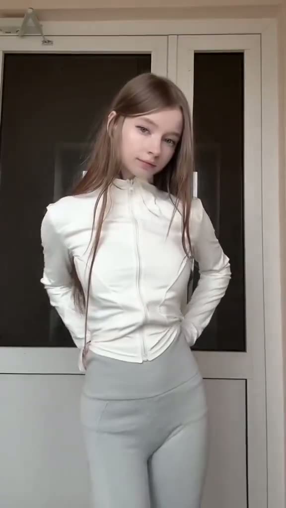 Brunette in a white zip-up top and leggings
