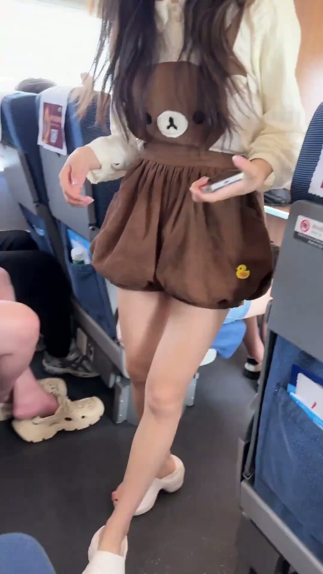 Brunette in a brown teddy-bear romper on an airplane