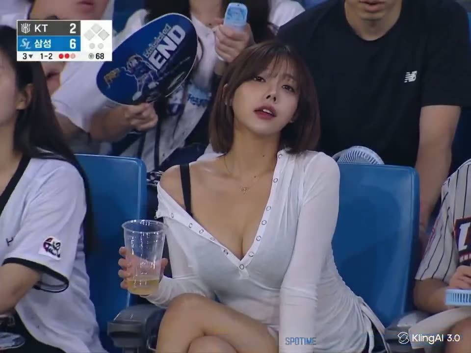 Woman in a white top at a baseball stadium