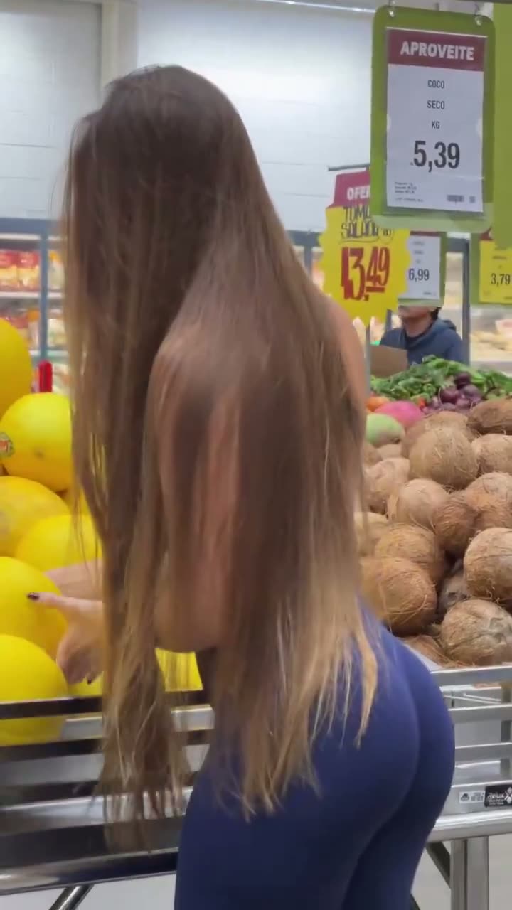 Brunette in blue leggings from behind at a market