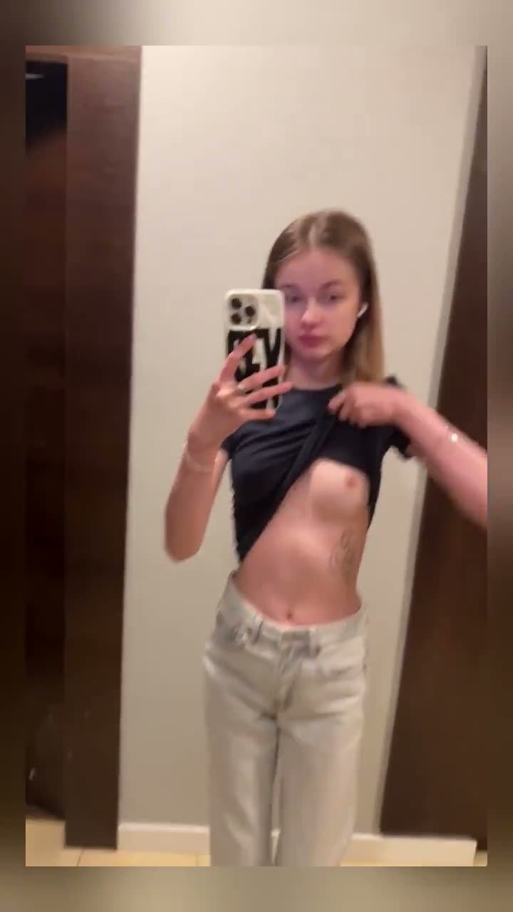 Blonde lifting a black top in a mirror selfie