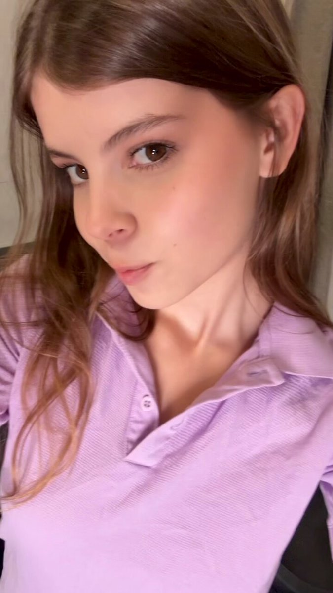 Brunette in a lavender polo taking a close-up selfie (@Zlnane118534)