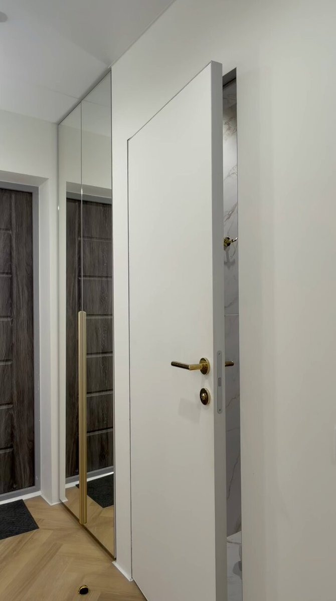 White hallway door cracked open by a gold handle (@justyoursandy)