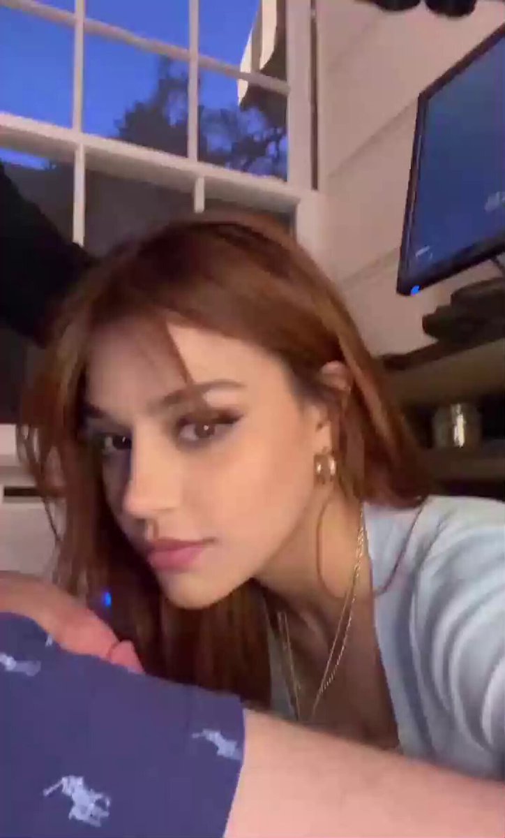 Redhead in a light top by a window (@itsvaleriee_0)