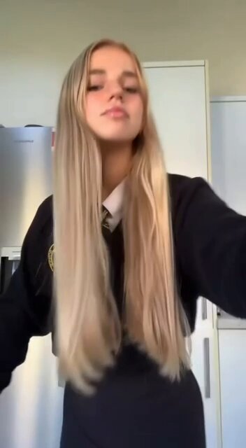 Blonde in a navy school sweater and tie taking a selfie (@avalabalaaa)
