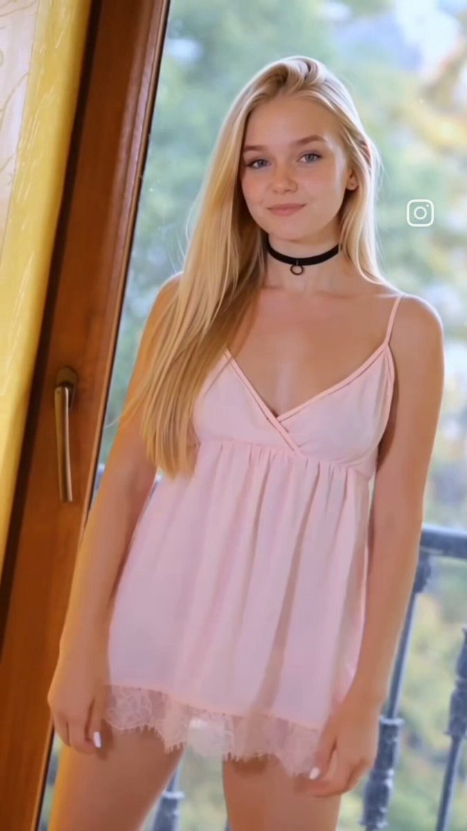 Blonde in a pink lace babydoll by a window (@LyraMaddox)
