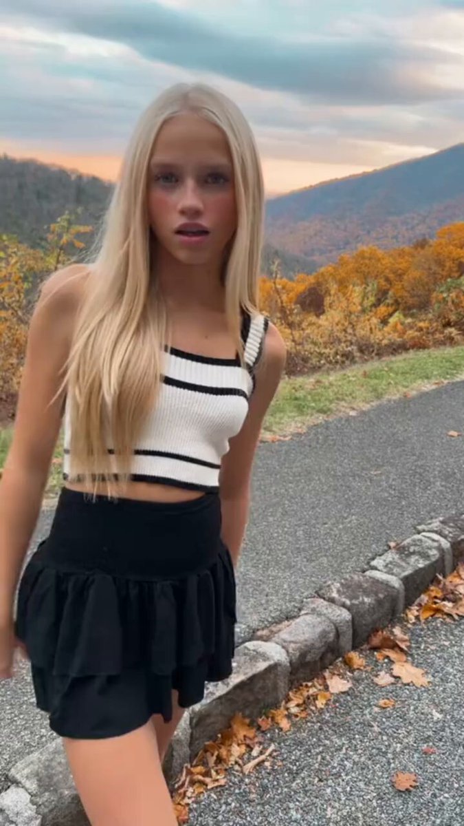 Blonde in a striped crop and black ruffle skirt on a mountain road (@TithiesBomme)