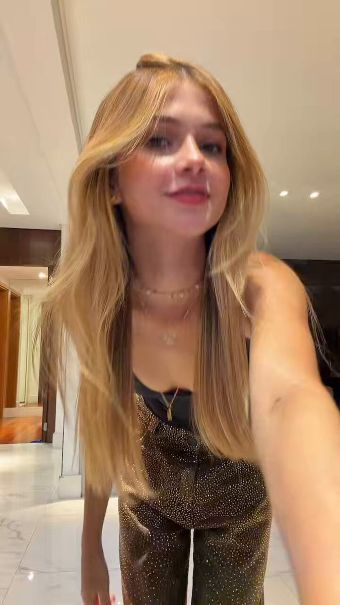Blonde in a black tank and sparkly brown pants taking a selfie (@sophiferr1)