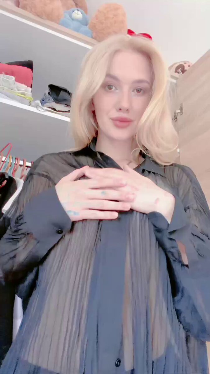 Blonde in a sheer dark gray button-up with hands on her chest (@susan30gl7)