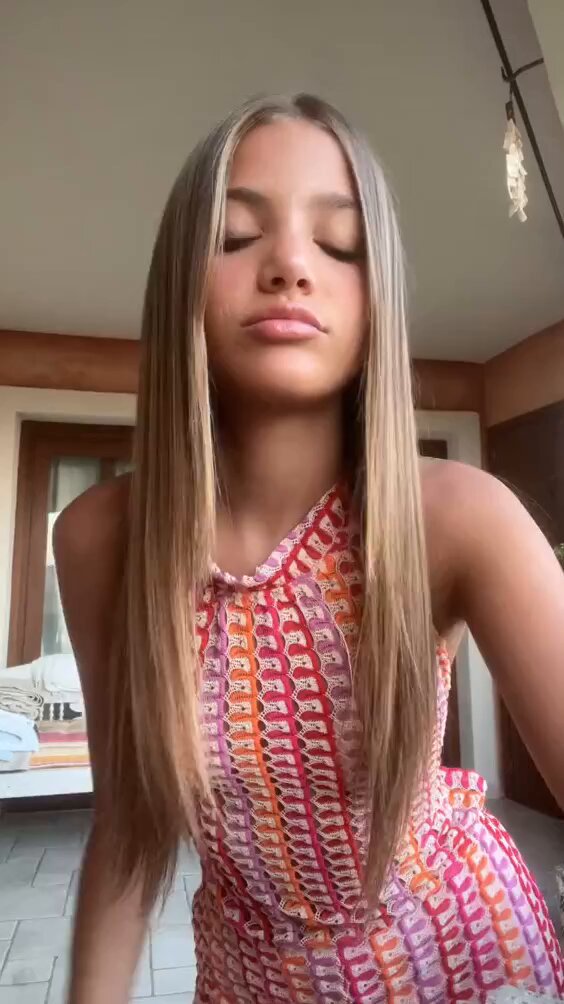 Blonde in a pink and orange patterned halter dress (@gulliaalberti)