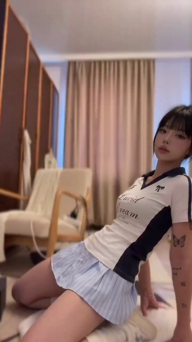 Brunette with bangs in a Lucid Dream polo and blue pleated skirt (@reguuiiu)