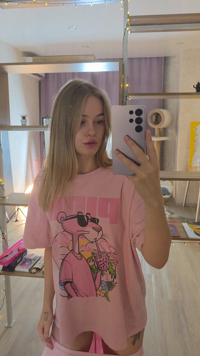 Blonde in an oversized pink cartoon tee taking a mirror selfie (@Dasnenemm)