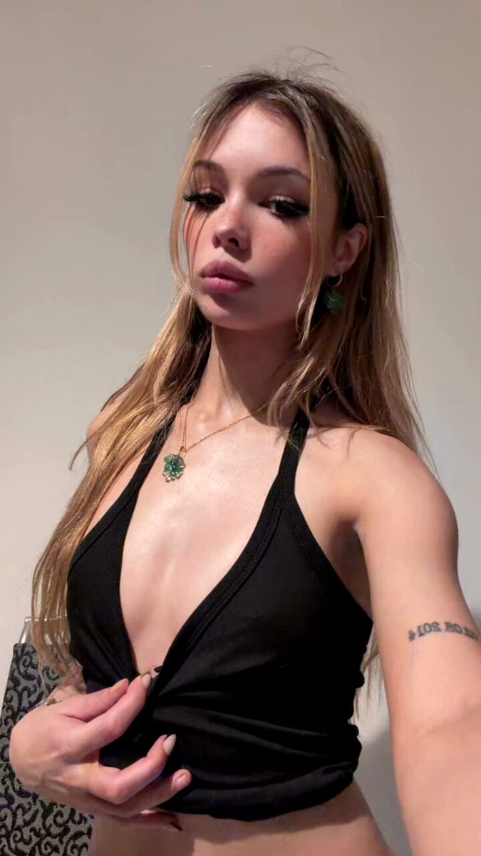 Blonde in a black plunging halter with a green clover necklace (@Lexi_onn)