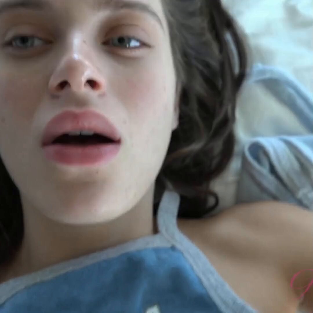 Brunette in a blue tank lying on a bed (@magicalldeup)