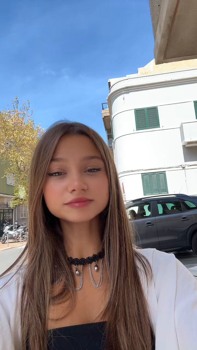 Brunette in a black lace chain choker and white jacket on a street (@Paultaylorom)
