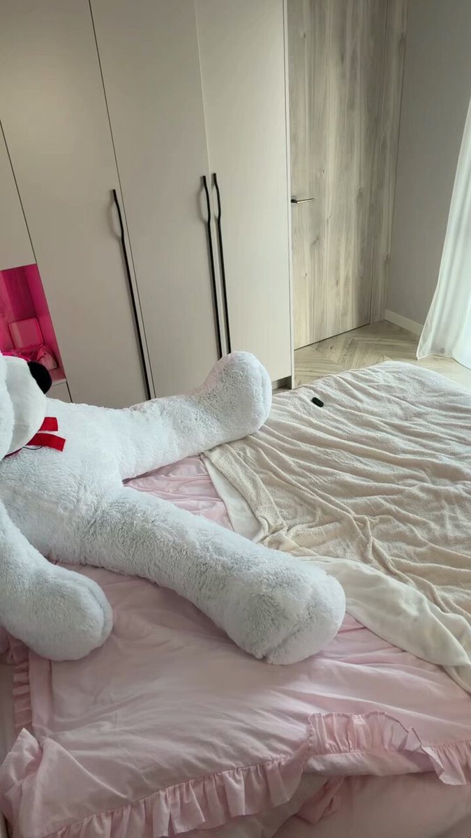 Brunette in a black crop top on a bed with a giant teddy bear (@rodarte52926)