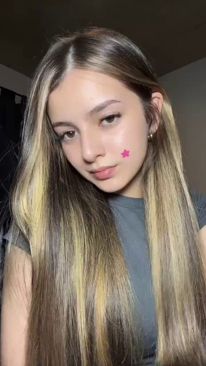 Brunette with blonde highlights and a pink star on her cheek in a gray tee (@LFATfxEdwin)