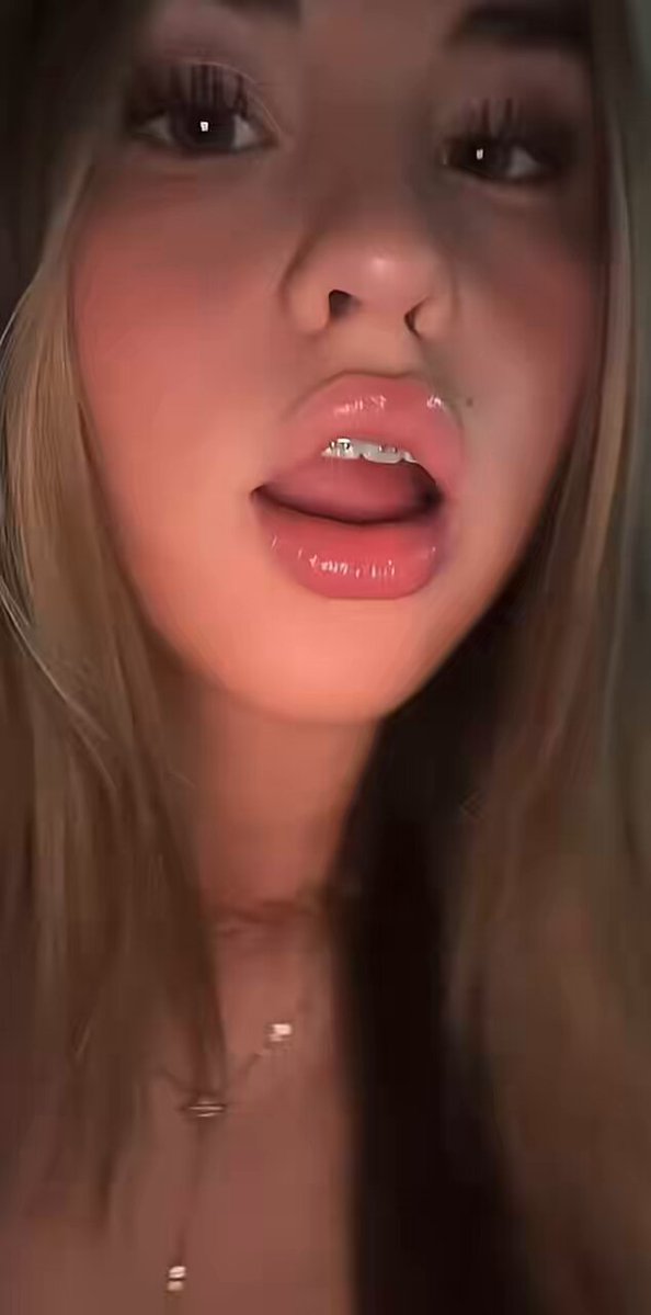 Blonde with glossy lips and a gold necklace in a close-up (@ehzhuaiix)