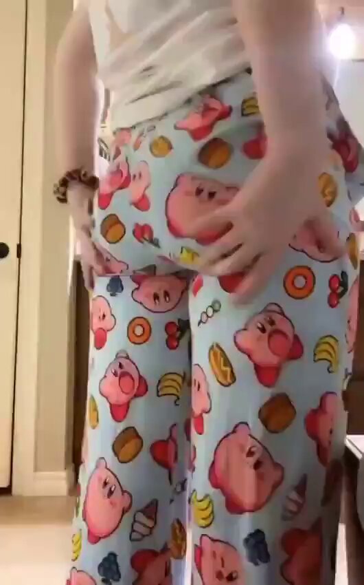 Woman in a white tank and blue Kirby-print pants from behind (@Nicoo_sg7)