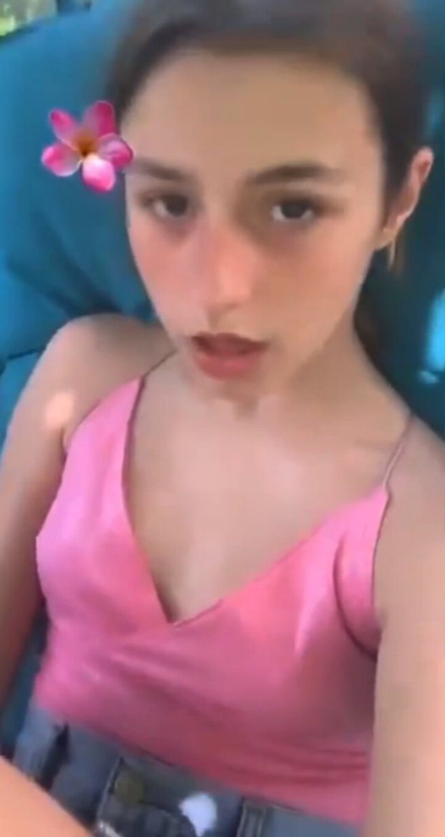 Brunette in a pink camisole with a pink flower in her hair