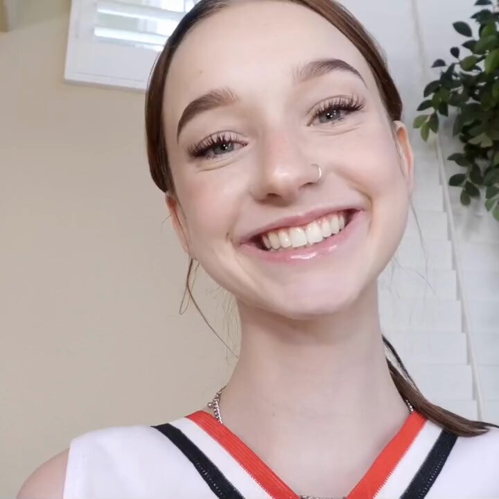 Brunette in a cheerleader outfit on a couch (@Momsaffections)