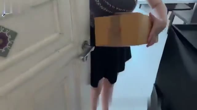 Brunette in a gray shirt holding a box at a door (@alisonsibrian)